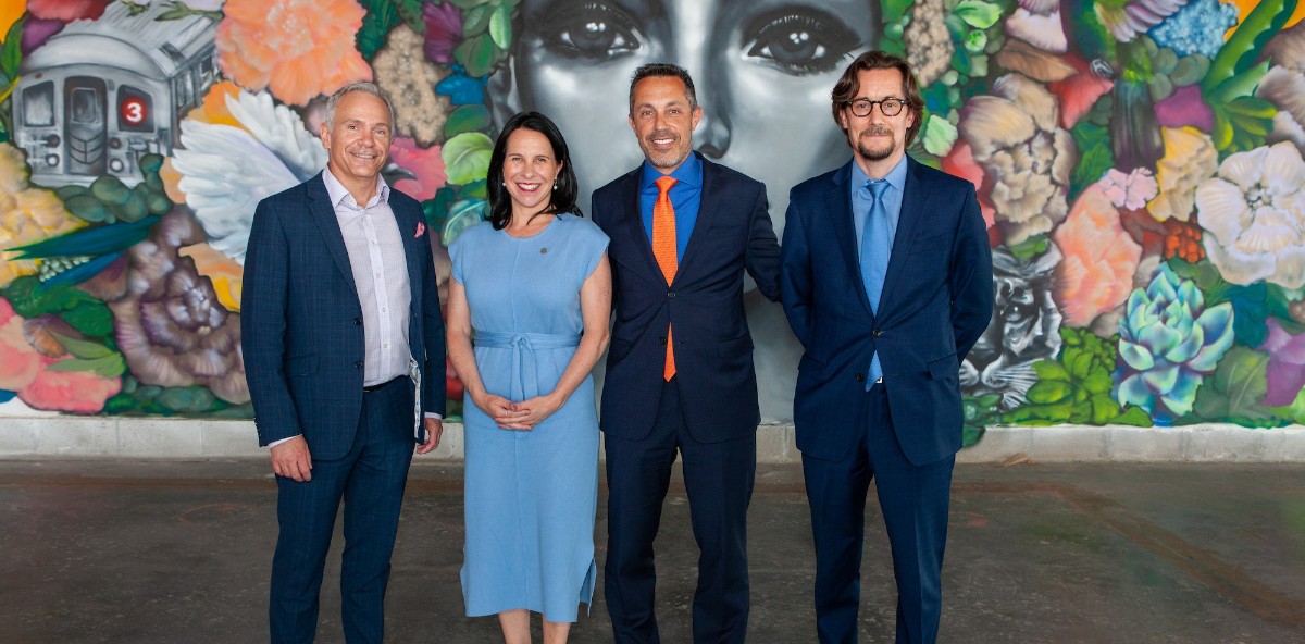 Four people posing for a picture, smiling